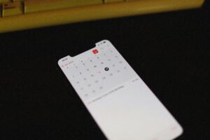 Smartphone with illuminated calendar app screen on a dark background, June 2021 visible.